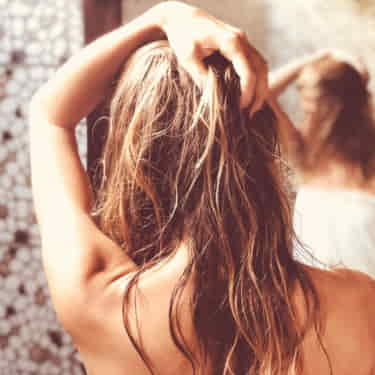 a women tests chlorine shampoo for swimmers in her dry hair