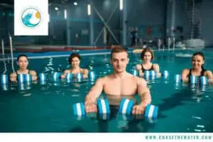 a group of swimmers holding aqua dumbells in the water
