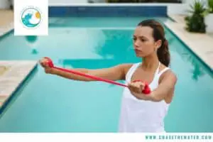 woman doing stretch cord resistance band exercises by the pool