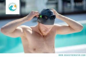 swimmer pulling swim cap and googles on head