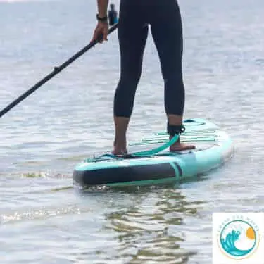 a woman paddle boards on a cost effective board