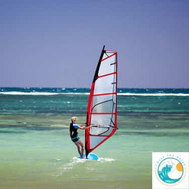 a woman windsurfs in the ocean